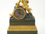 une horloge dorée et verte surmontée d'une statue