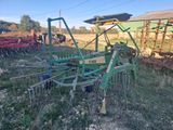 a tractor that is sitting in the grass with a plow
