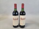 two bottles of red wine sitting next to each other on a table