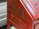 a small red desk with a drawer on it
