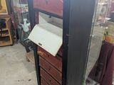 a tall black cabinet with drawers in a store