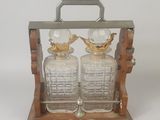 paire de carafes en verre posées sur un socle en bois, sur fond blanc
