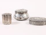 three silver objects sitting on top of a white surface next to each other
