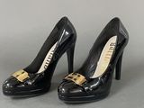 pair of black high heeled shoes with gold buckles on them