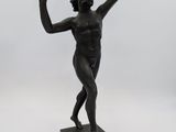 une statue noire représentant une femme tenant une fleur à la main