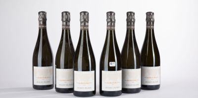 six bottles of wine are lined up in a row on a white surface