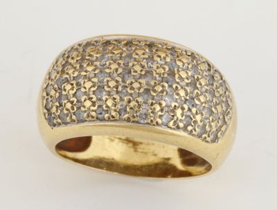 gros plan d'une bague en or et diamants sur une surface blanche