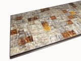 a brown and white tiled table with a metal base