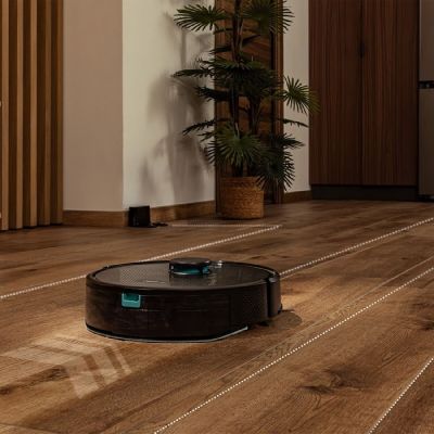 un robot posé par terre à côté d'une plante
