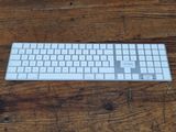 a white keyboard sitting on a wooden table