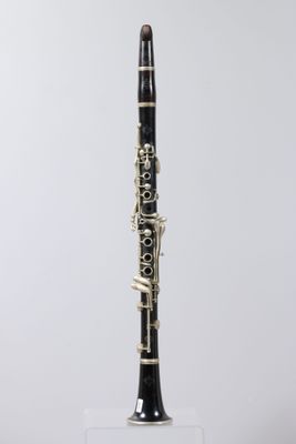 a black and white clarinet sitting on top of a clear stand
