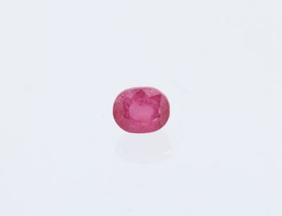 un gros plan d'un saphir rose posé sur une surface blanche