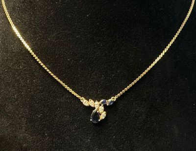 a gold necklace with a black and white stone pendant on a mannequin