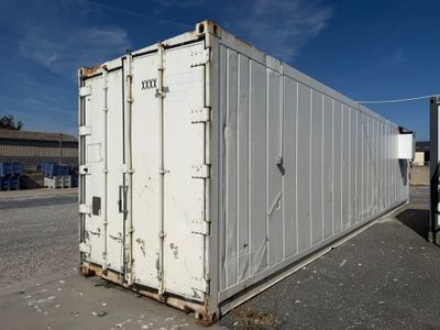 a white container sitting in the middle of a parking lot