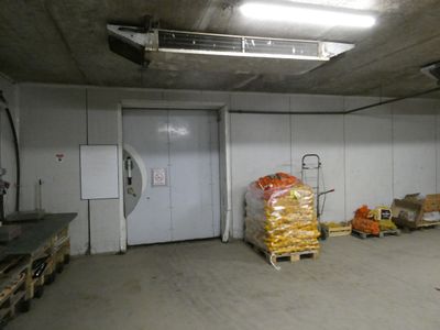 une pièce où se trouvent plusieurs sacs de nourriture posés sur des palettes