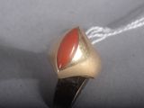 a gold ring with a red stone in it