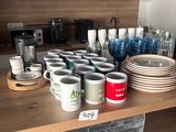 de nombreuses tasses et assiettes sur le plan de travail de la cuisine