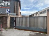 a gate in front of a building that has a sign on it