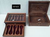 two wooden boxes with knives and spoons in them on a table