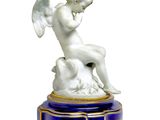 a statue of an angel sitting on top of a blue pedestal