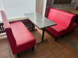 two red chairs and a table in the corner of a room