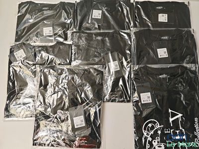 beaucoup de t-shirts noirs posés sur une table blanche