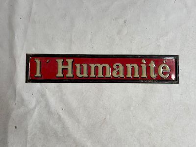 une pancarte rouge et noire sur laquelle on peut lire « i humanite »