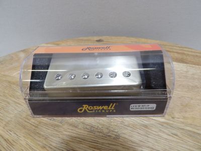 an image of a small guitar pickup sitting on top of a wooden table