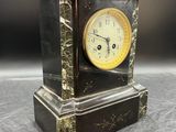 une horloge noire et or posée sur une table