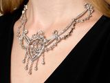 the woman is wearing a necklace that has a bunch of diamonds on it