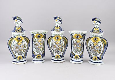 quatre vases ornés de fleurs et d'oiseaux sont alignés sur un fond gris