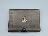 an antique silver cigarette case with a monogram on the front