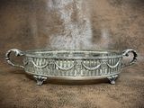 a large metal bowl with handles on a brown surface