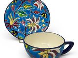 a close up of a cup and saucer on a white background