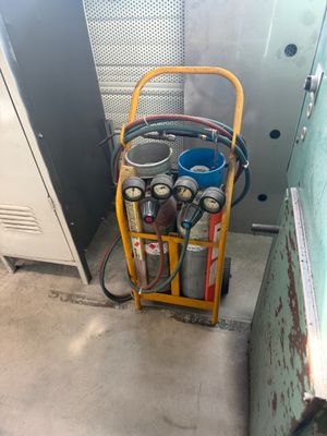 un chariot jaune sur lequel sont empilés plusieurs bidons d'essence