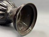 un vase en argent posé sur une table