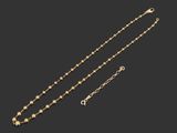a gold necklace and a pair of earrings on a black background