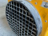 a yellow heater sitting on the ground in a warehouse
