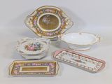 several different types of porcelain dishes and trays sitting on a table