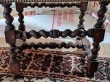 a small wooden table with a wooden top on a rug