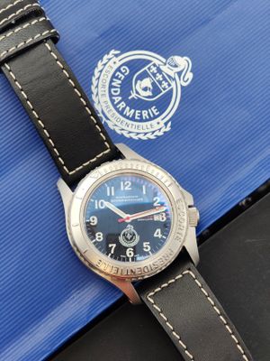 une image représentant une montre posée sur une boîte bleue