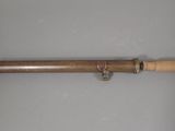 an old telescope with a wooden handle on a white surface