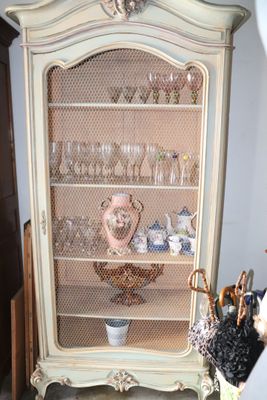 a cabinet with a glass door and a basket on top of it