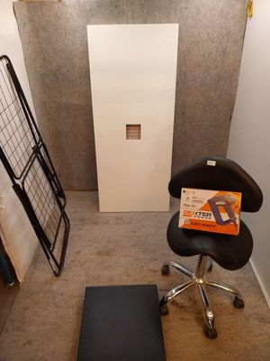 une chaise noire dans un coin d'une pièce, sur laquelle est posé un ordinateur portable