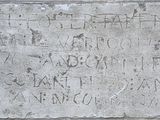 une plaque en pierre portant une inscription, fixée sur le mur d'un immeuble