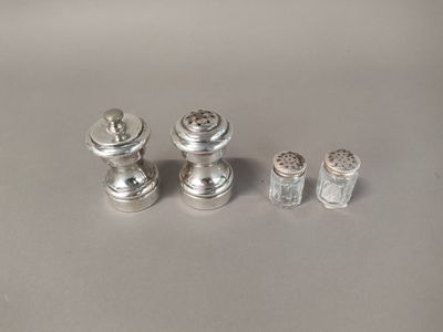 three salt and pepper shakers and a salt shaker on a table