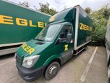 un camion de livraison vert garé sur un parking