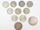 Plusieurs pièces de monnaie différentes sont disposées en triangle sur une surface blanche