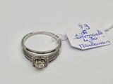 a silver ring with a diamond on it and a tag