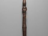 a close up of a wooden stick with a face on it